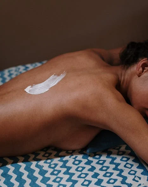 Une femme au dos nu est allongée sur une table de massage